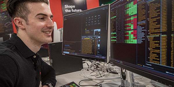 A student working on two computer screens.