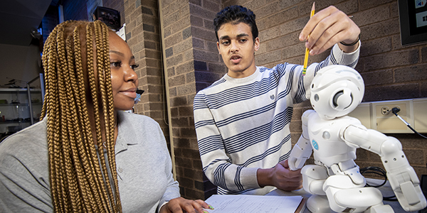 Two students working with a robot in the Innovation Center.