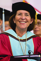 Portrait of President McMenamin smiling in full graduation regalia.