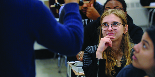 A student sitting in class and looking toward the speaker.