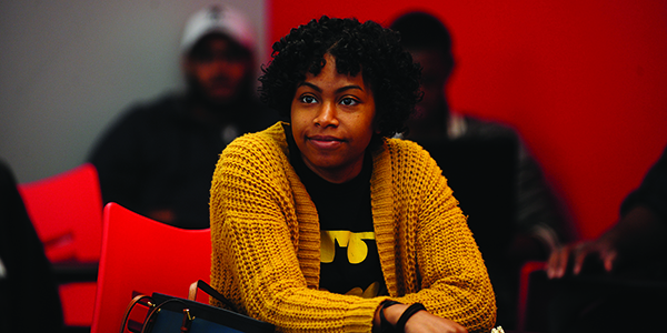 A student sitting in class and looking forward attentively.