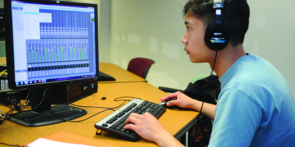 A student using entertainment technology software on a computer.