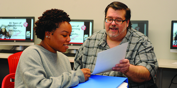 A professor and student discussing a document in class.