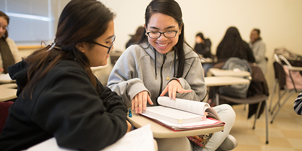 Two students looking at a textbook.