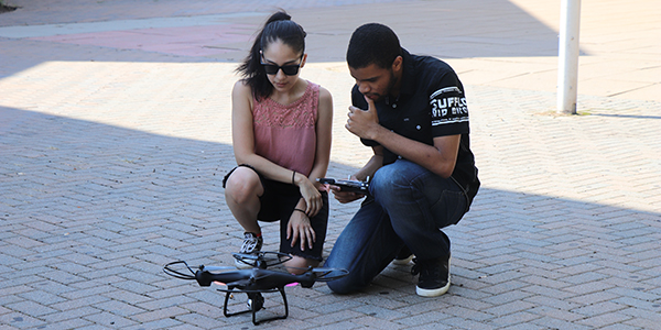 Two students working with a drone.