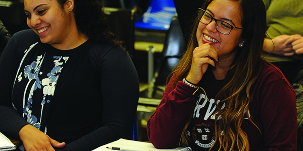Two students smiling in class.