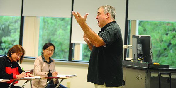 A professor speaking to students in a classroom.