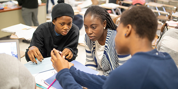 Three students working together in class.