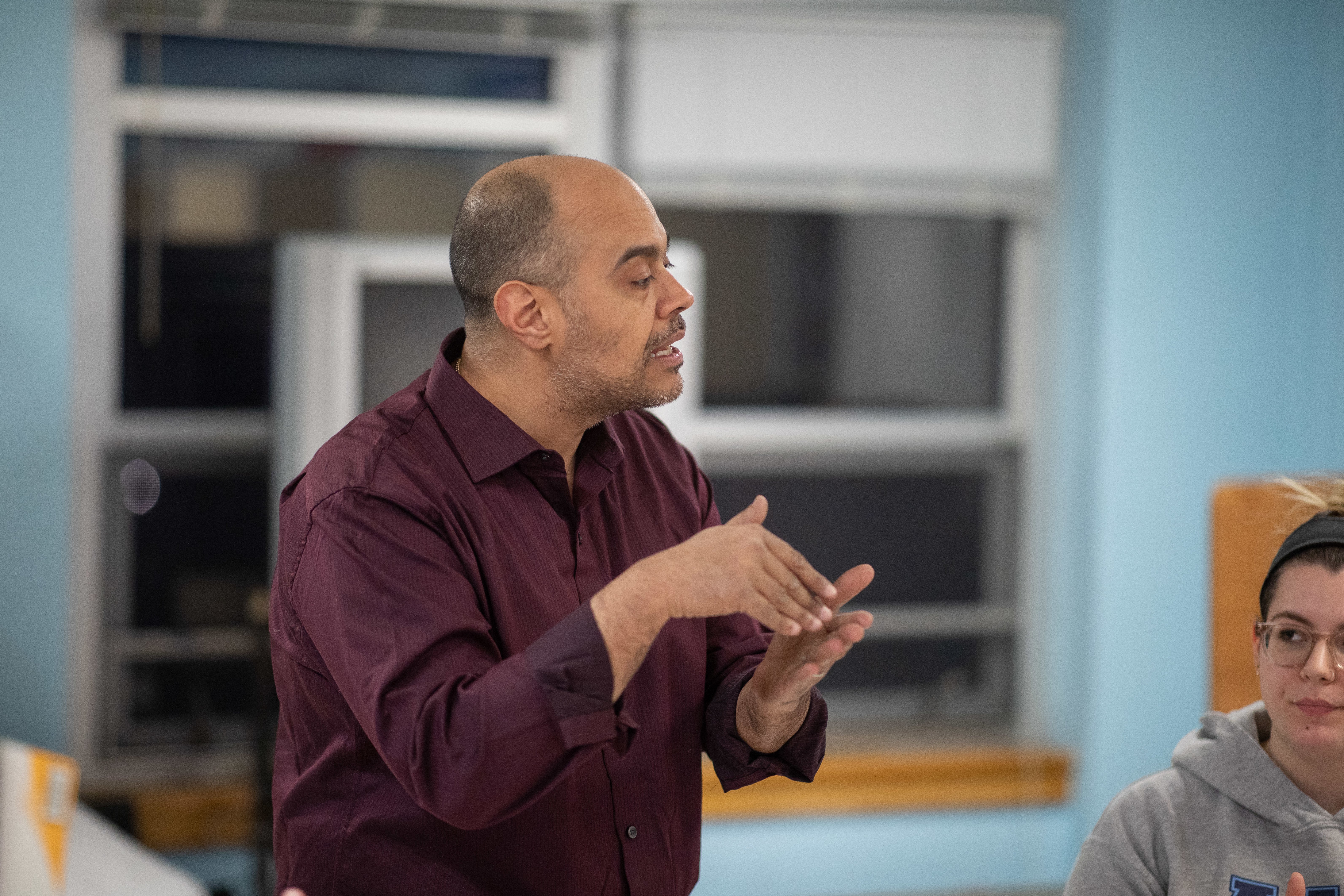 A professor using sign language in a classroom setting.